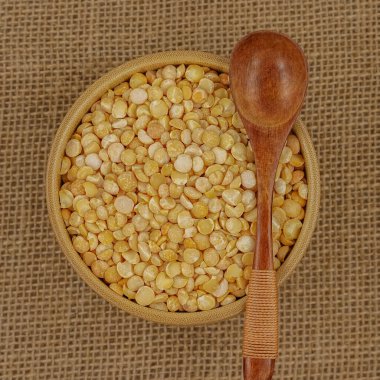 Çuval bezi dokusuna tahta kaşık ve kaşık ile işlenmemiş sarı tabak.