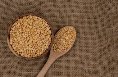 Çuval bezi dokusuna tahta kaşık ve kaşık ile işlenmemiş sarı tabak.