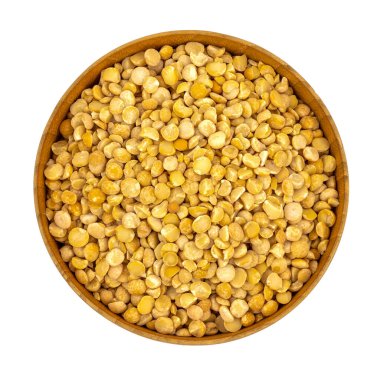 Tahta bir tabakta çiğ sarı bezelyeler (kase) beyaz arka planda izole edilmiş, tepeden aşağı görünüm