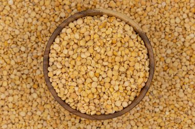 Bezelye desenli ahşap bir tabakta çiğ sarı bezelye.