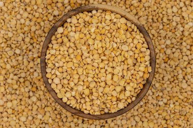 Bezelye desenli ahşap bir tabakta çiğ sarı bezelye.