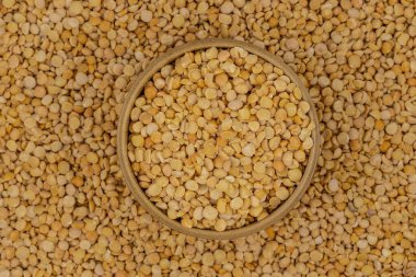 Bezelye desenli ahşap bir tabakta çiğ sarı bezelye.