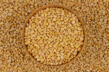 Bezelye desenli ahşap bir tabakta çiğ sarı bezelye.