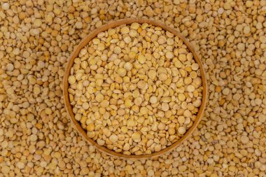 Bezelye desenli ahşap bir tabakta çiğ sarı bezelye.