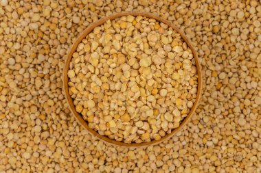 Bezelye desenli ahşap bir tabakta çiğ sarı bezelye.