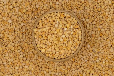 Bezelye desenli ahşap bir tabakta çiğ sarı bezelye.