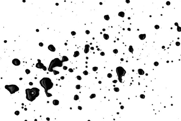 Drops of black paint splattered on a white background, texture