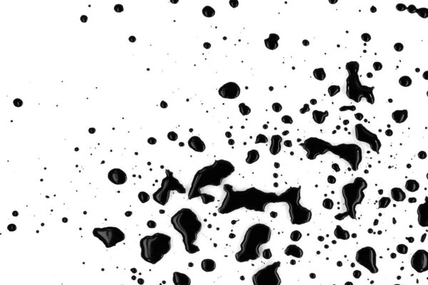 Drops of black paint splattered on a white background, texture