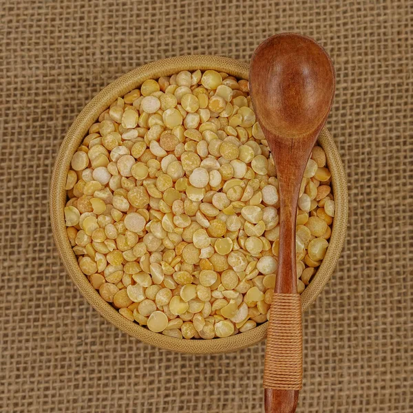 Çuval bezi dokusuna tahta kaşık ve kaşık ile işlenmemiş sarı tabak.