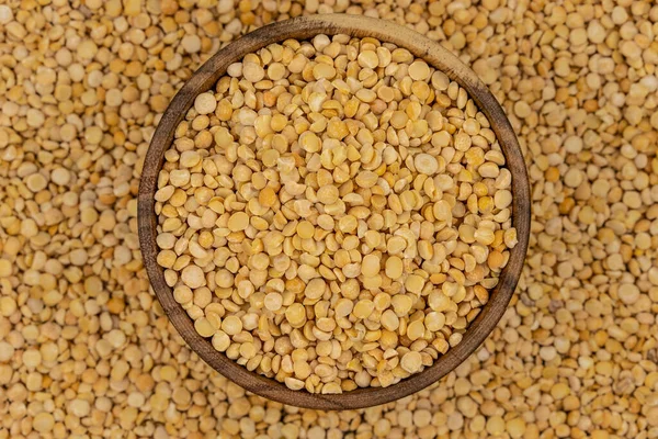 Bezelye desenli ahşap bir tabakta çiğ sarı bezelye.