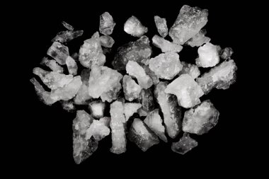 Dökülmüş beyaz deniz tuzu izole edilmiş siyah arka plan. Siyah zemin üzerinde kristal sallayıcı çakıl taşlarını temizle, makro, kapat