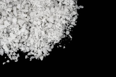 Dökülmüş beyaz deniz tuzu izole edilmiş siyah arka plan. Siyah zemin üzerinde kristal sallayıcı çakıl taşlarını temizle, makro, kapat