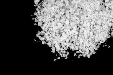 Dökülmüş beyaz deniz tuzu izole edilmiş siyah arka plan. Siyah zemin üzerinde kristal sallayıcı çakıl taşlarını temizle, makro, kapat