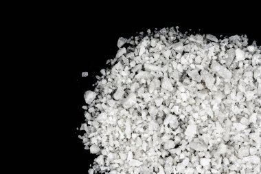 Dökülmüş beyaz deniz tuzu izole edilmiş siyah arka plan. Siyah zemin üzerinde kristal sallayıcı çakıl taşlarını temizle, makro, kapat