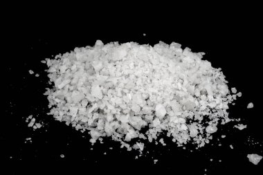 Dökülmüş beyaz deniz tuzu izole edilmiş siyah arka plan. Siyah zemin üzerinde kristal sallayıcı çakıl taşlarını temizle, makro, kapat