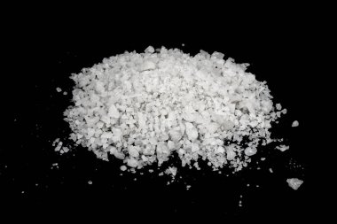 Dökülmüş beyaz deniz tuzu izole edilmiş siyah arka plan. Siyah zemin üzerinde kristal sallayıcı çakıl taşlarını temizle, makro, kapat