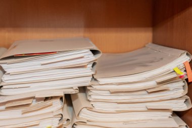 Arşivde birikmiş eski kağıt belgeler. Belgeler arşiv odasının raflarında. Ofis rafları dosyalarla dolu dolapta.