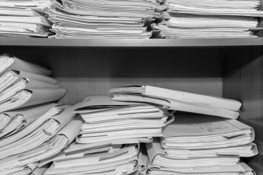 Belgeler arşivde duruyor. Belgeler arşiv odasının raflarında. Ofis rafları dosyalarla dolu dolapta. siyah beyaz fotoğraf