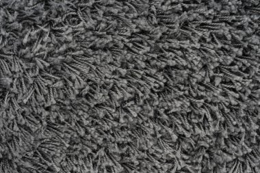 Siyah doğal yün halı dokusu. Koyu renk yün kumaş. Parça gri tüylü paspas