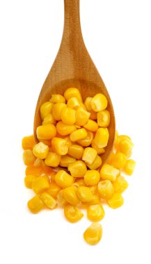 Beyaz arka planda izole edilmiş tahta kaşıkta mısır tohumları.