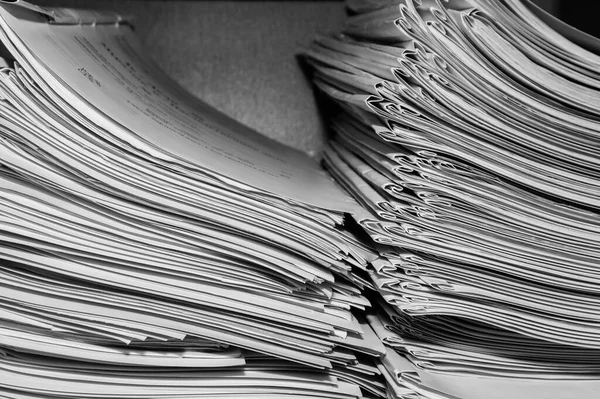 Paper documents stacked in archive. Documents on the shelves of archive room. Office shelves in the closet full of files. black and white photo