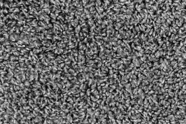 Black natural fleece carpet texture background. Dark wool fabric texture. fragment gray shaggy mat