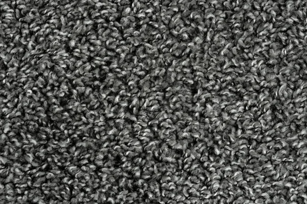 Black natural fleece carpet texture background. Dark wool fabric texture. fragment gray shaggy mat