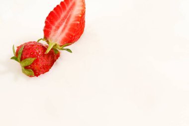 Kırmızı doğal olgun çilekler süt kremasına dökülüyor.