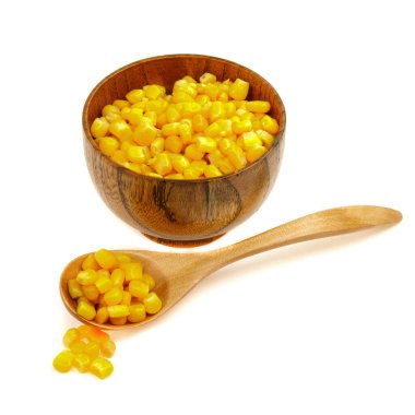 Tahta kaşıkta mısır tohumu ve beyaz arka planda izole edilmiş fincan tabağı.