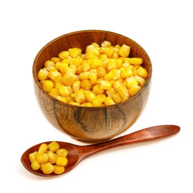 Tahta kaşıkta mısır tohumu ve beyaz arka planda izole edilmiş fincan tabağı.