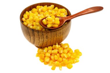 Tahta kaşıkta mısır tohumu ve beyaz arka planda izole edilmiş fincan tabağı.