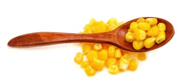 Beyaz arka planda izole edilmiş tahta kaşıkta doğal mısır tohumları.