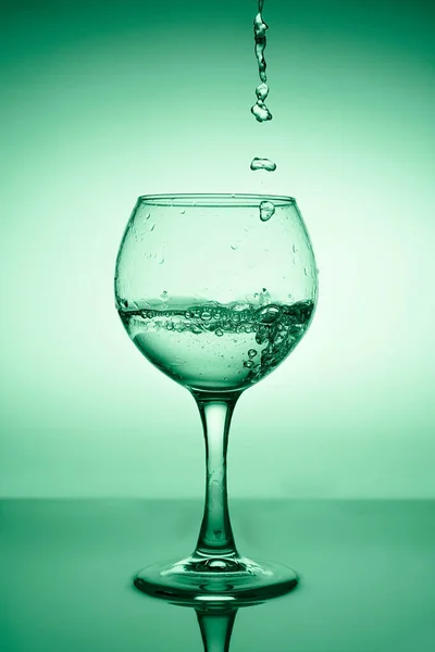 Ποτήρι Κρασιού Τρεχούμενο Νερό Λευκός Οίνος Φόντο Πράσινης Διαβάθμισης — Φωτογραφία Αρχείου