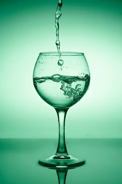 Ποτήρι Κρασιού Τρεχούμενο Νερό Λευκός Οίνος Φόντο Πράσινης Διαβάθμισης — Φωτογραφία Αρχείου