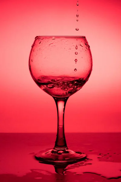 Fluindo Líquido Vinho Copo Fundo Vermelho — Fotografia de Stock