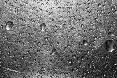 Kazınmış metal arka planda su damlaları. Yakın plan.