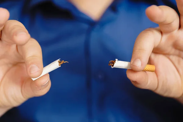 Erkek eli sigarayı kırıyor. Araba konseptinde sigara içmeyi bırak. Sigarayı elle yok et.