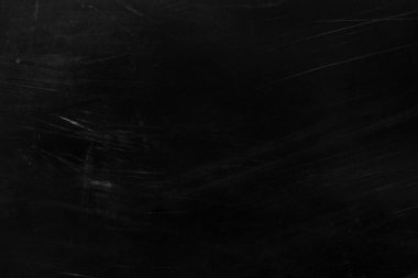 Beyaz çizikler ve aşınma dokusu olan eski siyah bir duvar. tebeşir ve çatlaklarla kaplı grunge siyah tahtası