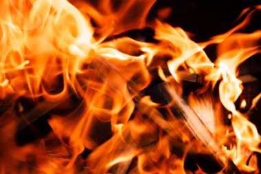 Siyah arka planda ateş alevinin dokusu. Ocakta yanan bir ateş.