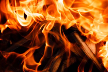 Siyah arka planda ateş alevinin dokusu. Ocakta yanan bir ateş.