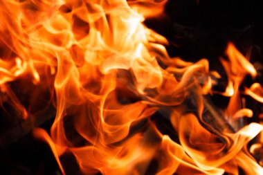 Siyah arka planda ateş alevinin dokusu. Ocakta yanan bir ateş.