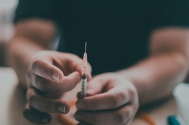 Şırınga eroin metamfetamin bağımlılığıyla masada duran bir bağımlı.