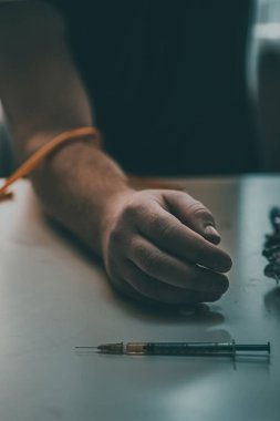 Şırınga eroin metamfetamin bağımlılığıyla masada duran bir bağımlı.