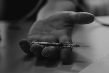 Şırınga eroin metamfetamin bağımlılığıyla masada duran bir bağımlı.