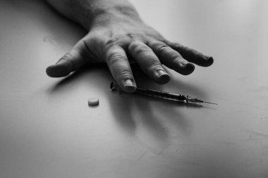 Şırınga eroin metamfetamin bağımlılığıyla masada duran bir bağımlı.