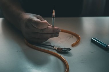 Şırınga eroin metamfetamin bağımlılığıyla masada duran bir bağımlı.