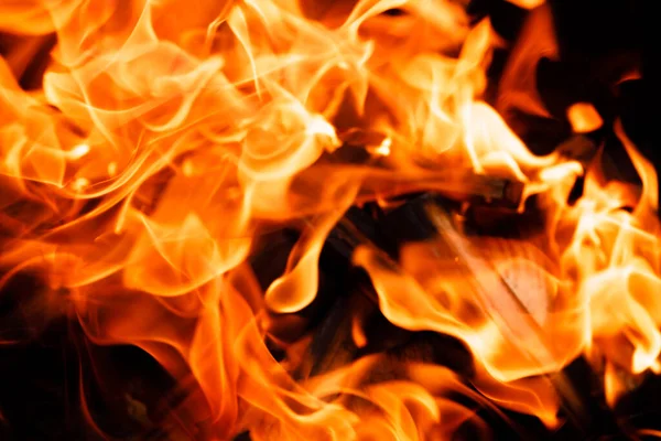 黒い背景に火の炎の質感 ストーブの上で火を焚く — ストック写真