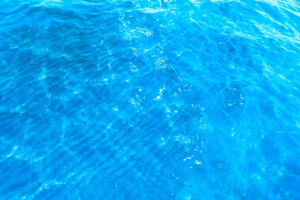 靠近海滩纹理背景的蓝色透明海水 晴朗的水面 阳光普照 波涛汹涌 — 图库照片