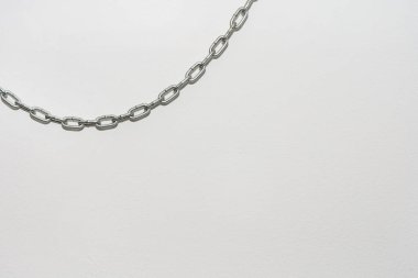 Beyaz zemin duvarda asılı demir zincir