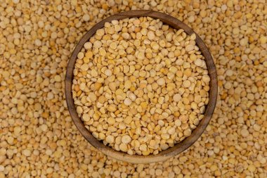 Bezelye desenli ahşap bir tabakta çiğ sarı bezelye.